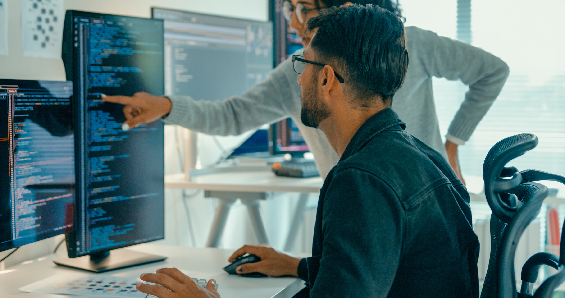 A financial professional analyzing AI-related investment data on multiple screens in a modern office